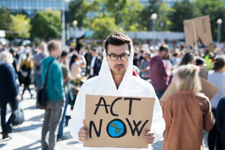 Man with placard and protective suit on global strike for climate change